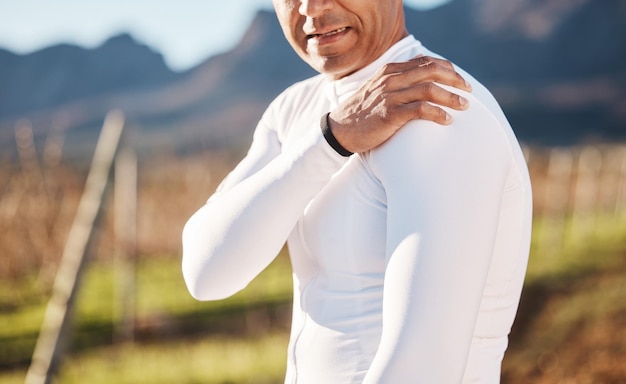 Foto braço da mão e lesão com um corredor ao ar livre para exercícios de cardio ou resistência na natureza dor no ombro e emergência com um atleta do sexo masculino sofrendo de cãibra após um acidente durante a corrida