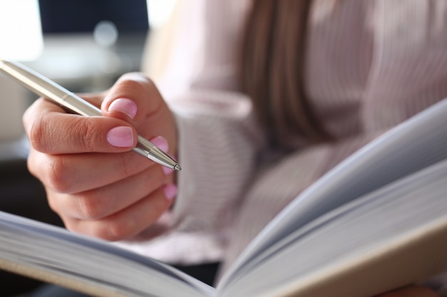 Braço de balconista feminino fazer marcas no bloco de notas