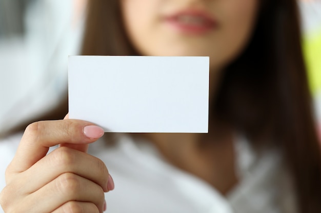 Braço feminino em terno dar cartão de visita em branco para o visitante