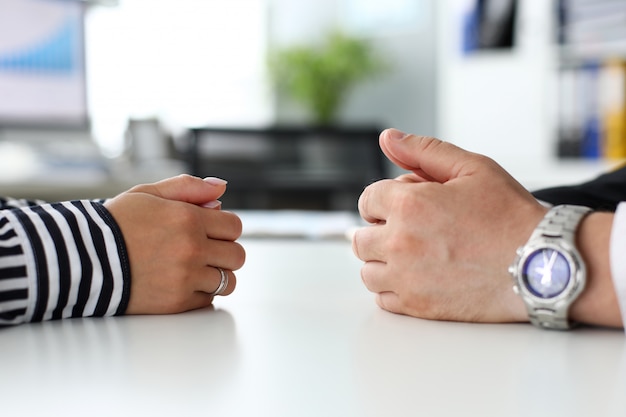 Braços masculinos e femininos, deitado no lado oposto da mesa, comunicando-se