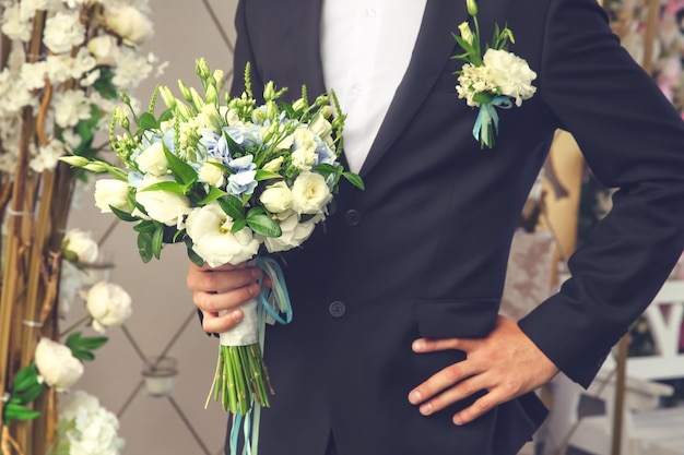 Bräutigam mit Blumenstrauß im Hochzeitssaal