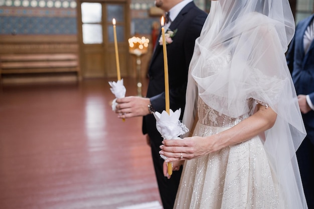 Foto bräutigam und braut halten eine kerze in der hand