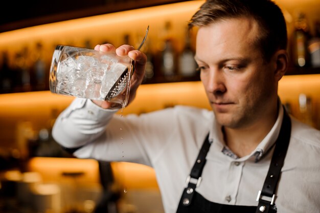 Braga, misturando coquetel alcoólico com gelo usando filtro e copo