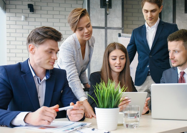 Brainstorming Gruppe von Geschäftsleuten, die gemeinsam auf den Laptop schauen