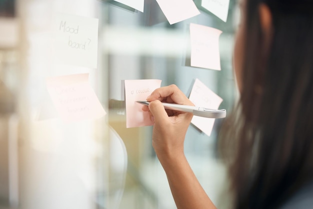 Foto brainstorming mit den händen und frau, die notizen für die tagesordnung des büros und mindmap-ziele am fenster schreibt nahaufnahme einer mitarbeiterin, die ideen am glas für lösungsinformationen und strategieziele plant