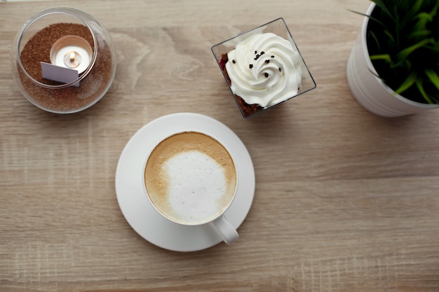 Branca xícara de cappuccino quente em pires branco