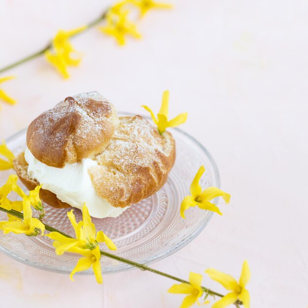 Brandteigbrötchen mit Schlagsahne und Puderzucker darauf Brandteigdessert Französischer Windbeutel