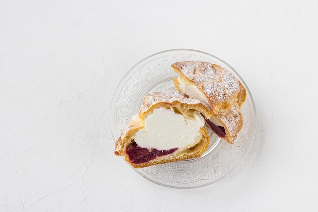 Brandteigbrötchen mit Schlagsahne und Puderzucker darauf Brandteigdessert Französischer Windbeutel