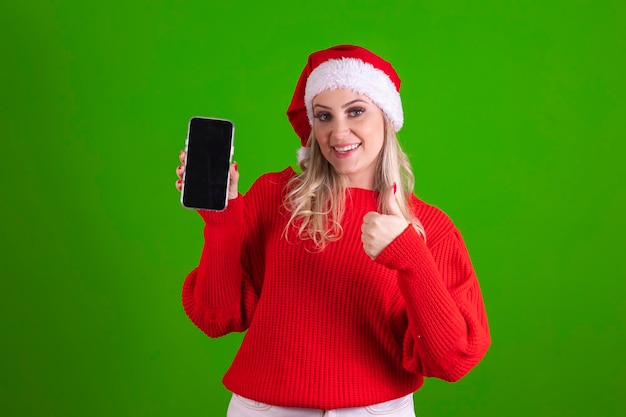 Brasilianerin im Weihnachtsmann-Outfit mit Smartphone mit weißem Bildschirm im Chroma-Hintergrund