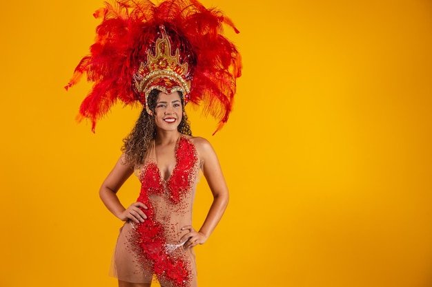 Brasilianische Afro-Frau posiert im Samba-Kostüm über gelbem Hintergrund mit freiem Speicherplatz. Brasilianisch gekleidetes Samba-Kostüm.