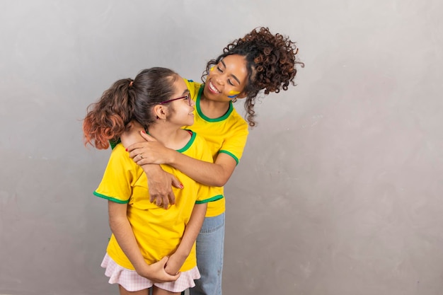 Brasilianische Familienfans von Brasilien Afro-Mutter und Tochter mit brasilianischer Kleidung Muttertag