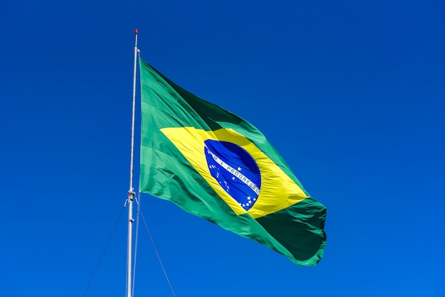 Brasilianische Flagge gehisst mit blauem Himmel