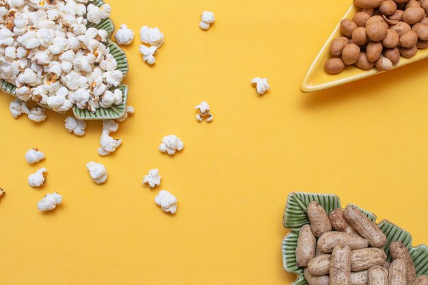 Brasilianische Juni-Party-Snacks wie Popcorn-Erdnüsse und Mais auf gelbem Hintergrund