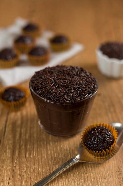 Brasilianische Schokoladensüße namens Brigadeiro im Topf auf hölzernem Schreibtischhintergrund Vegane Version