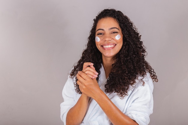 Brasilianische schwarze Frau mit Bademantel und Handtuch Gesichtscreme Spa Beauty Center Hautpflege