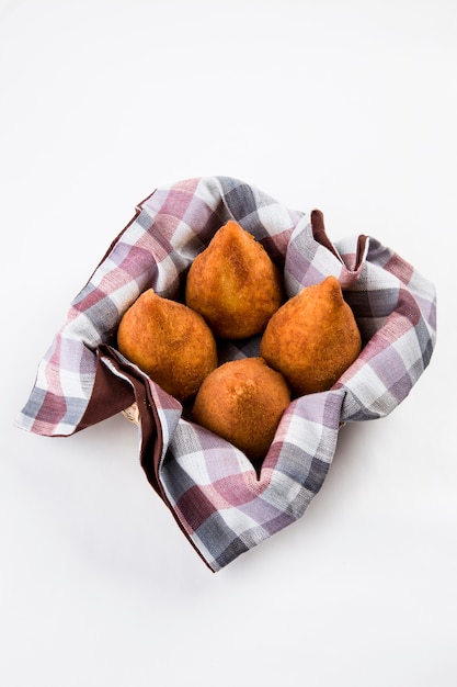 Brasilianischer Coxinha auf einer weißen Wand.