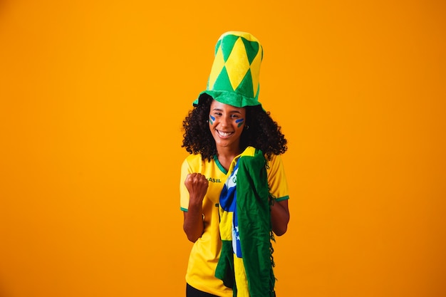 Brasilianischer Fan. Brasilianischer Fan, der Fußball- oder Fußballspiel auf gelbem Hintergrund feiert. Farben Brasiliens.