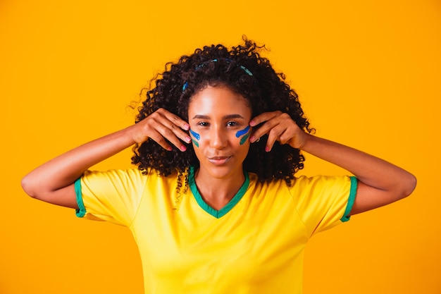 Brasilianischer Fan. mit Farbe als Make-up, brasilianischer Fan, der Fußball oder Fußballspiel feiert. Farben Brasiliens.