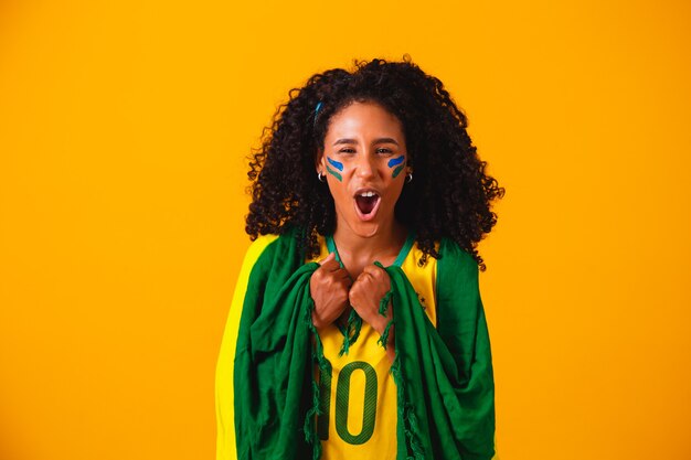 Brasilianischer Fan. Tragen der brasilianischen Flagge in einem Porträt, brasilianischer Fan, der Fußball oder Fußballspiel feiert. Farben Brasiliens.WM