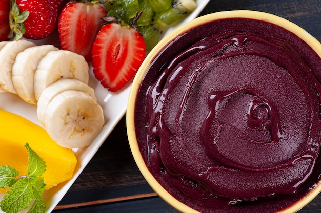 Brasilianischer gefrorener Açaí in einer Schüssel, begleitet von tropischen Früchten. Frucht des Amazonas