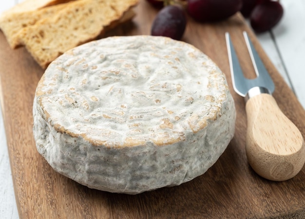 Brasilianischer Handwerker Bofete Blauschimmelkäse mit Brotnüssen und Früchten über Holztisch