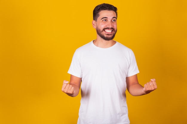 Brasilianischer lateinamerikanischer Mann mit Armen, der den glücklichen Sieger des Glücks-Freude-Gewinners zuversichtlich feiert