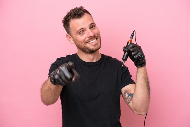 Brasilianischer Mann des Tätowierers lokalisiert auf rosa Hintergrund, der Front mit glücklichem Ausdruck zeigt