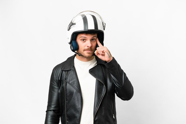 Brasilianischer Mann mit Motorradhelm vor isoliertem weißem Hintergrund denkt über eine Idee nach