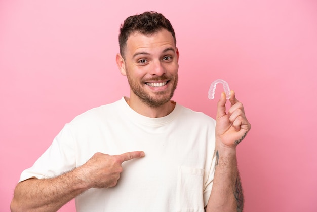 Brasilianischer Mann mit unsichtbaren Zahnspangen mit überraschendem Gesichtsausdruck