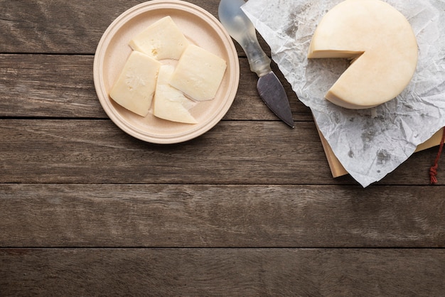 Brasilianischer Mantiqueira handwerklicher Käse mit Scheiben über einem Holztisch. Draufsicht mit Kopierraum.