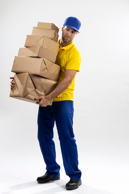 Brasilianischer Postbote auf einem weißen Hintergrund, der ein Paket liefert. Speicherplatz kopieren.