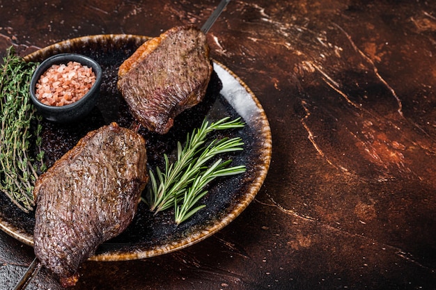 Brasilianisches BBQ gegrilltes trocken gealtertes Picanha-Rindsteak mit Kräutern Dunkler Hintergrund Draufsicht Kopierbereich