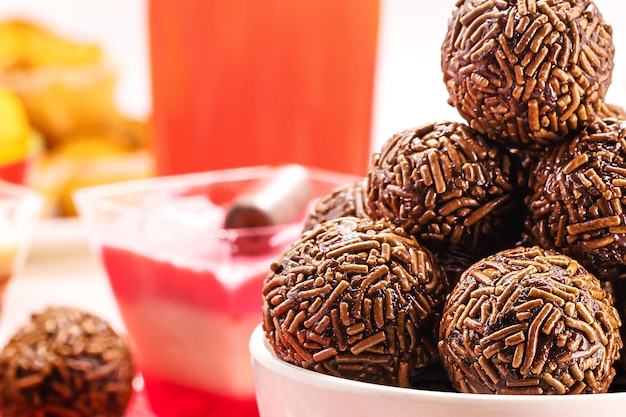 Brasilianisches Schokoladenbonbon namens Brigadeiro aus Kondensmilchschokoladenpulver und Streuseln, serviert mit Kuchen auf Geburtstagsfeiern Makrofotografie