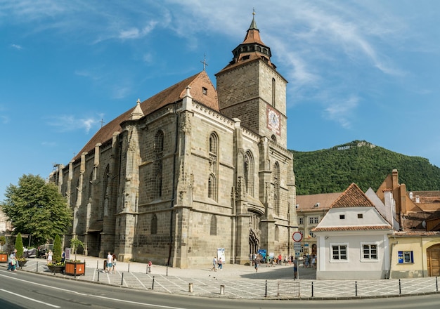 BRASOV RUMÄNIEN 10. august 2019 Menschen, die auf der George Baritiu Street spazieren gehen und die berühmte Schwarze Kirche im Zentrum von Brasov Rumänien beobachten