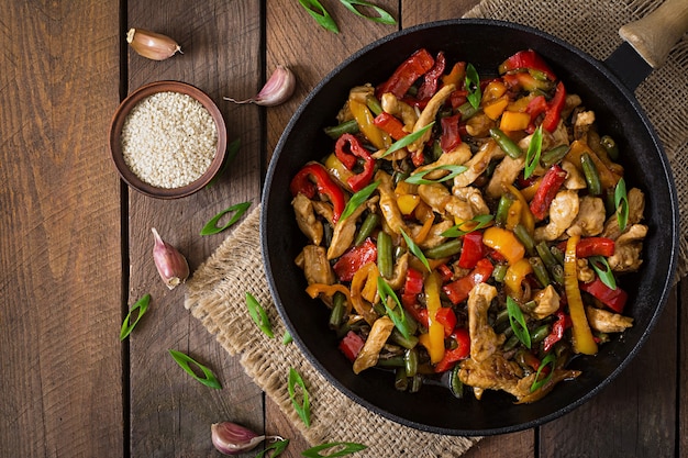 Braten Sie Hühnchen, Paprika und grüne Bohnen an