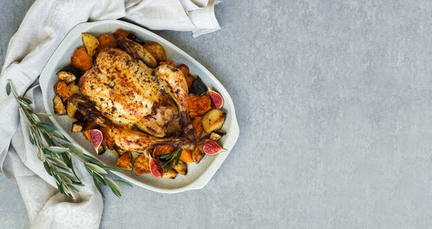 Brathähnchen mit Rosmarin und Süßkartoffel. serviert auf grauem Stein, lateinamerikanisches Essen, Draufsicht