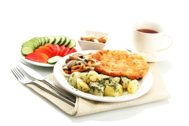 Brathähnchenkotelett mit Salzkartoffeln und Pilzen Tasse Tee, isoliert auf weiss