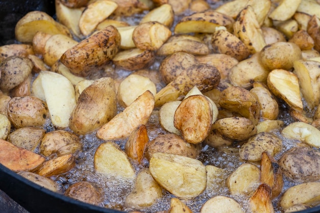 Bratkartoffeln in einer großen Pfanne Junge Kartoffeln werden in Öl gebraten Street Food