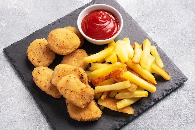 Bratkartoffeln und Hühnernuggets mit Tomatensauce