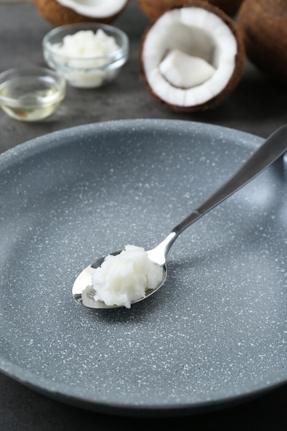 Bratpfanne mit Bio-Kokosöl und Löffel auf dem Tisch in Nahaufnahme