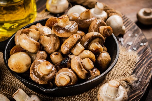 Bratpfanne mit gebratenen Pilzen auf einem Holztablett