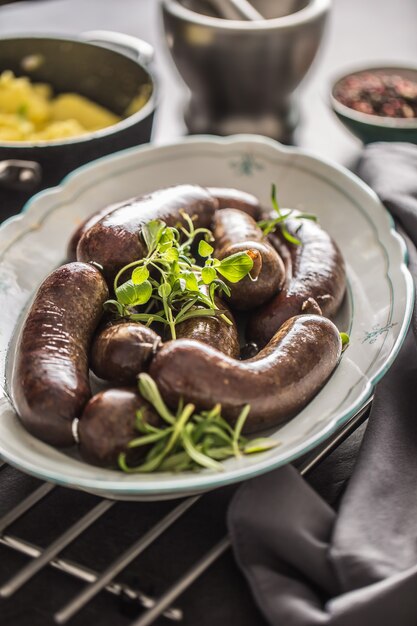 Bratwürste in der Pfanne mit Rosmarin. Traditionelle europäische Bratwurst Jaternice oder Jitrnice.