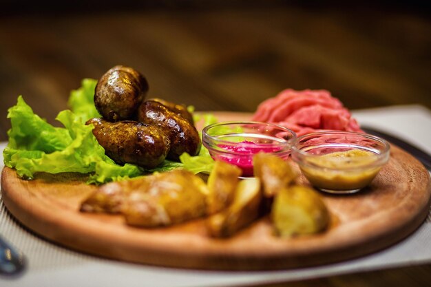 Bratwürste mit Kartoffeln und Senfsaucen im Restaurant