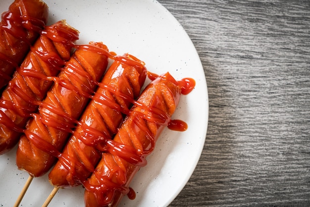 Bratwurstspieß mit Ketchup auf weißem Teller