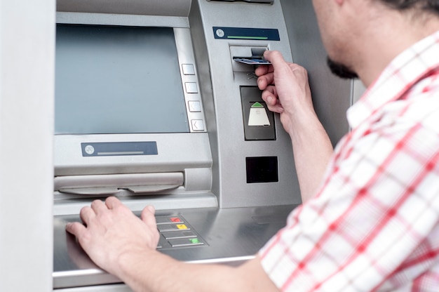 Brauchen Sie etwas Geld. Nahaufnahme eines Mannes, der seine Kreditkarte am ATM verwendet