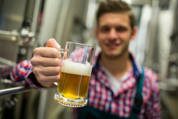 Brauer hält ein Glas Bier