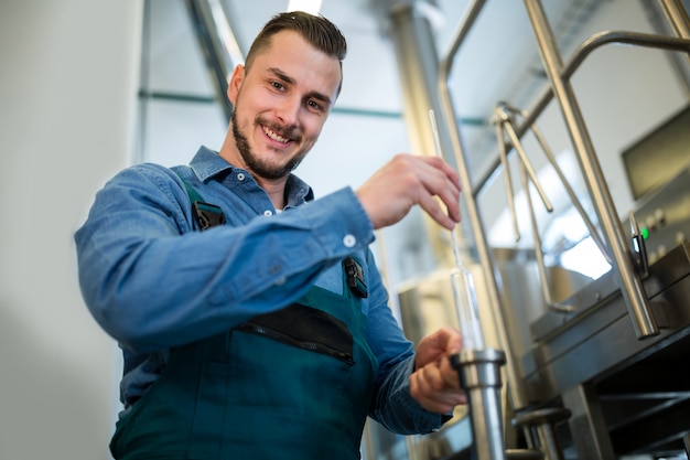 Foto brauer prüft bier mit hydrometer