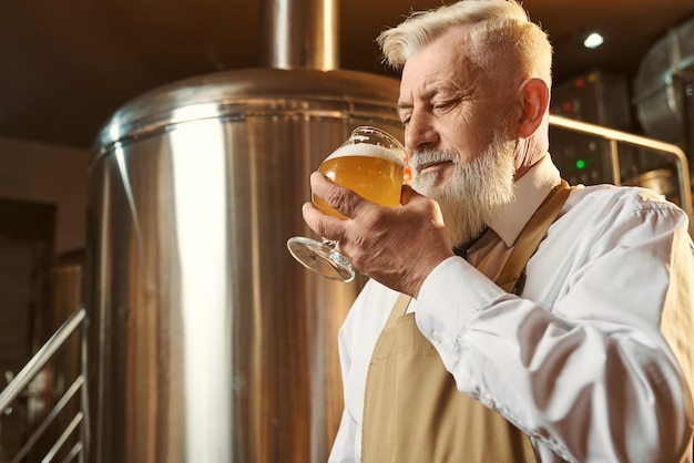 Foto brauereiexperte probiert kaltes großes bier mit schaum