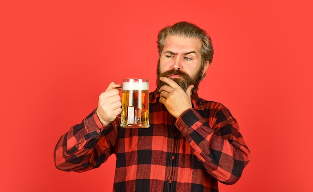 Brauhaus reifer bärtiger Barmann hält Bierglas selbstbewusster Barkeeper, der Toast anhebt Freizeit und Feier Mann trinkt Bier in der Kneipenbar Bier mit Schaum brutaler Hipster trinkt Bier