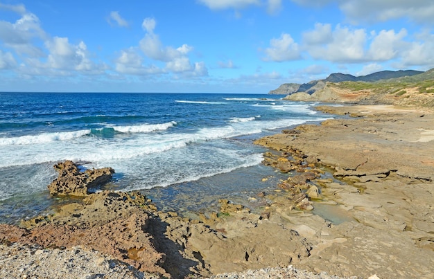 Braune Felsen und raue See in Argentiera Sardinien